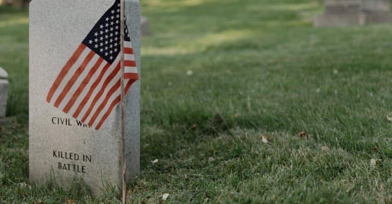 a-gravestone-with-an-american-flag-in-a-cemetery-honoring-a-civil-war-veteran - AC Flag & Banner Expert Flagpole Installation Services: Enhance Aesthetics and Ensure Safety - AC Flag & Banner